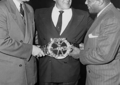 New York Yankees pitcher Allie Reynolds and his 1951 Hickok Belt are flanked by Ray Hickok (left) and heavyweight boxing champion Jersey Joe Wolcott.